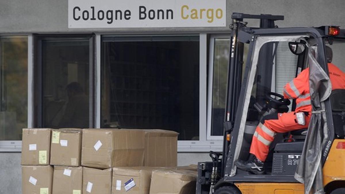 Un operario traslada paquetes comerciales en el aeropuerto de carga de Colonia, en Alemania, hoy.