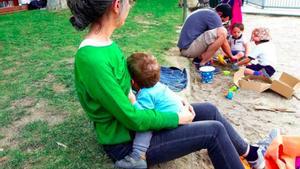 Una madre amamanta a su bebé en un parque de Madrid