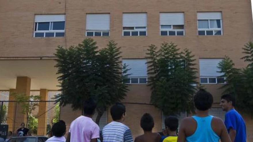Un grupo de jóvenes observa la ventana de la segunda planta desde donde cayó el niño.