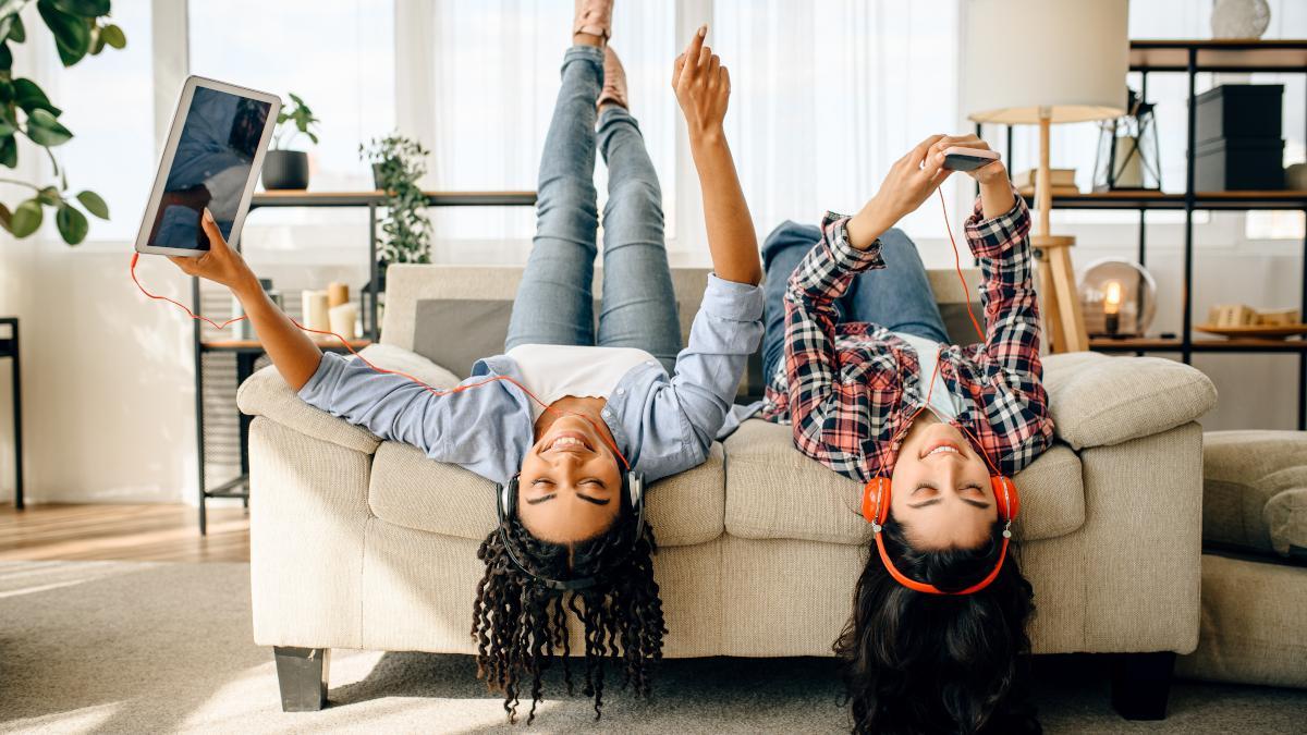 Dos chicas jóvenes escuchan música con auriculares.