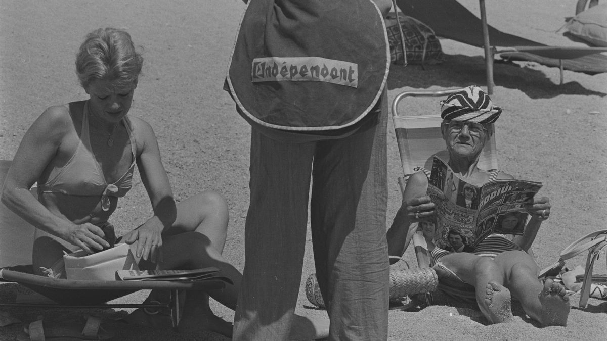 Venedor ambulant de L’Indépendant en plena platja. Platja d’Aro, juliol de 1974.