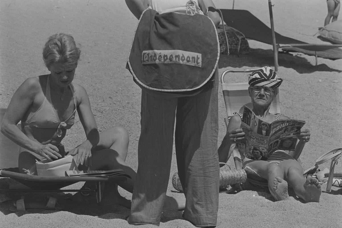 Venedor ambulant de L’Indépendant en plena platja. Platja d’Aro, juliol de 1974.