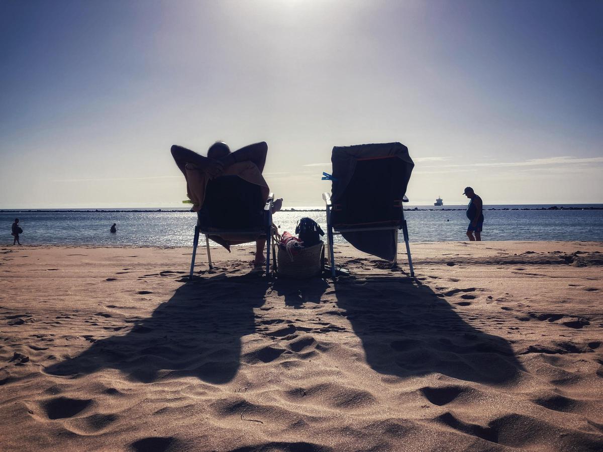 Dos personas toman el sol en la Playa de las Teresitas