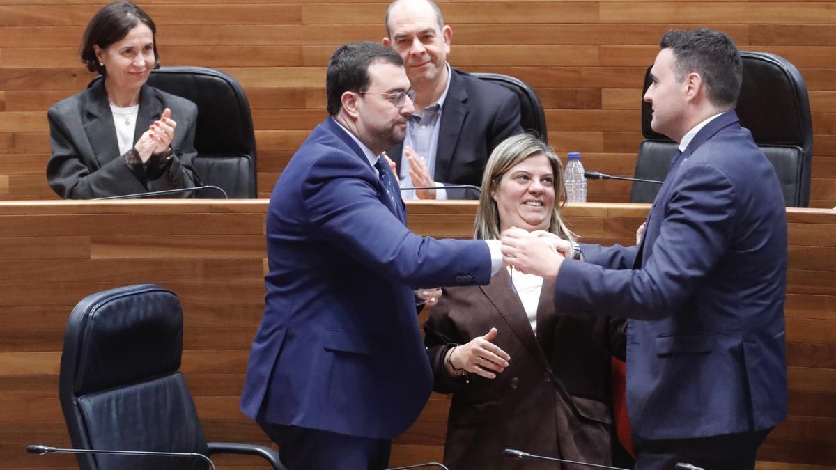 Adrián Barbón estrecha la mano a Guillermo Peláez tras la aprobación del Presupuesto, ante Gimena Llamedo. Detrás, Dolores Carcedo y Luis Ramón Fernández Huerga.