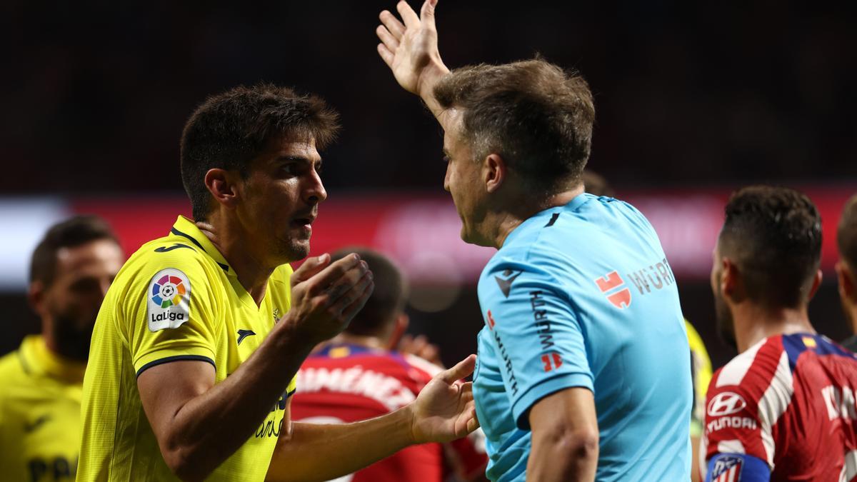 Gerard Moreno se queja a De Burgos Bengoetxea de la amarilla mostrada por celebrar su gol en el Atlético-Villarreal.