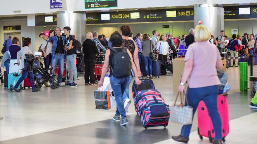 Varios pasajeros con maletas en el aeropuerto de Gran Canaria.