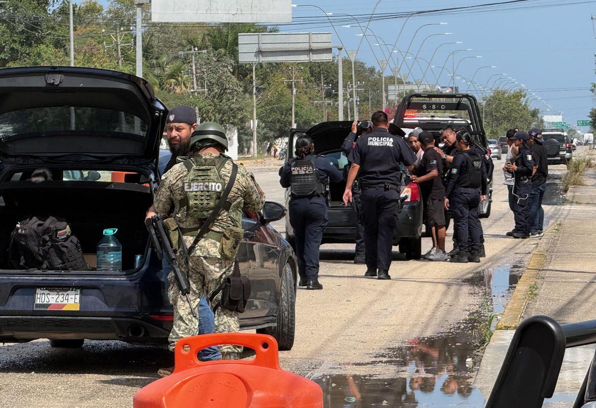 Miembros del Ejército mexicano y policías estatales revisan vehículos en el balneario de Cancún, en Quintana Roo.