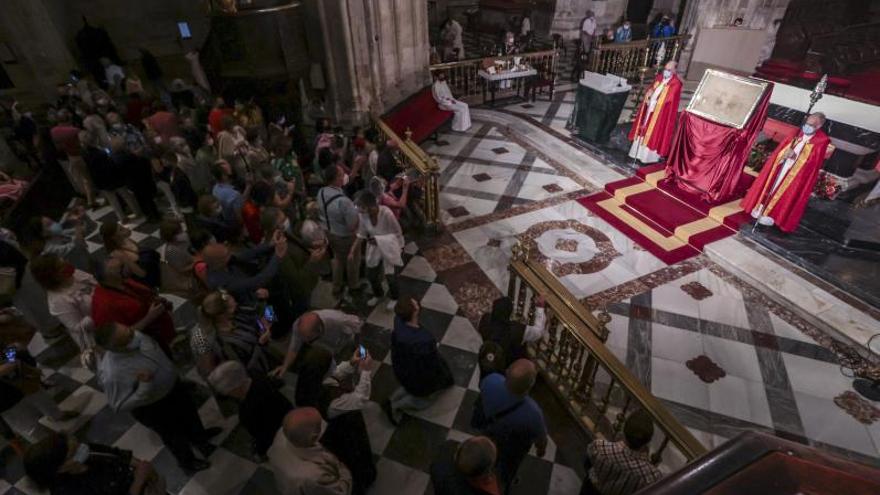 Los fieles veneran el Santo Sudario tras la misa.