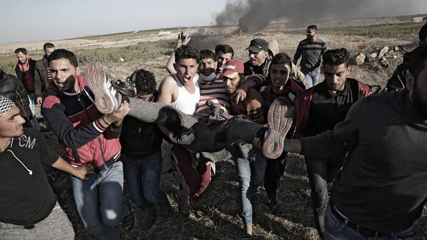 Un grupo de palestinos traslada a un herido en Gaza.