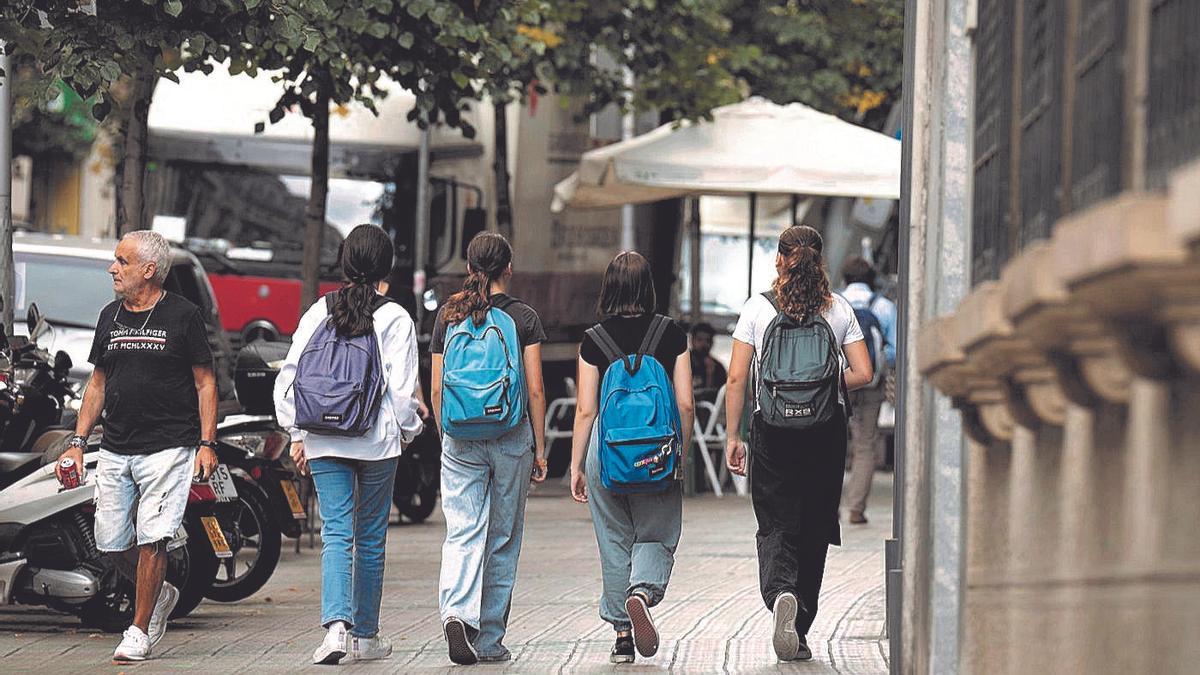 Cuatro adolescentes caminan a la salida de un instituto