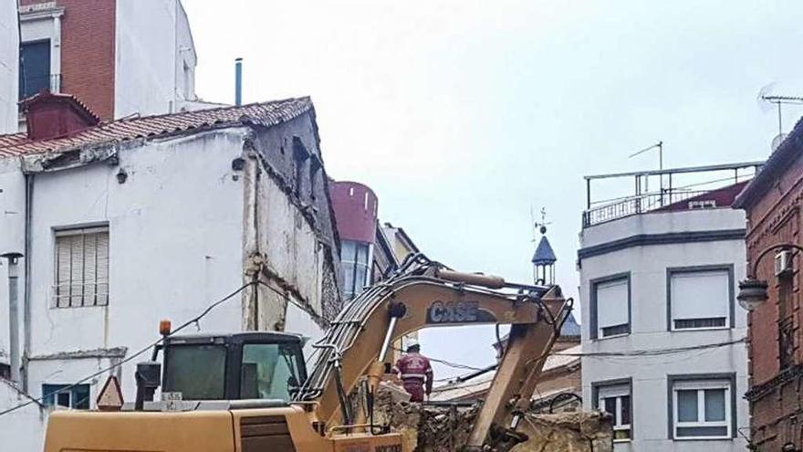 Una excavadora derriba el muro y la pared del número 2 a última hora de la tarde tras un día de trabajos.