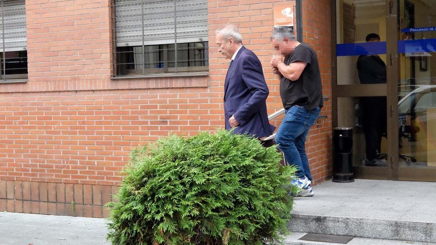 El hombre, con camiseta negra, sale del juzgado tras quedar en libertad, tras su abogado.