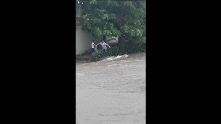 Madre e hijo son arrastrados por la corriente de una calle inundada en México