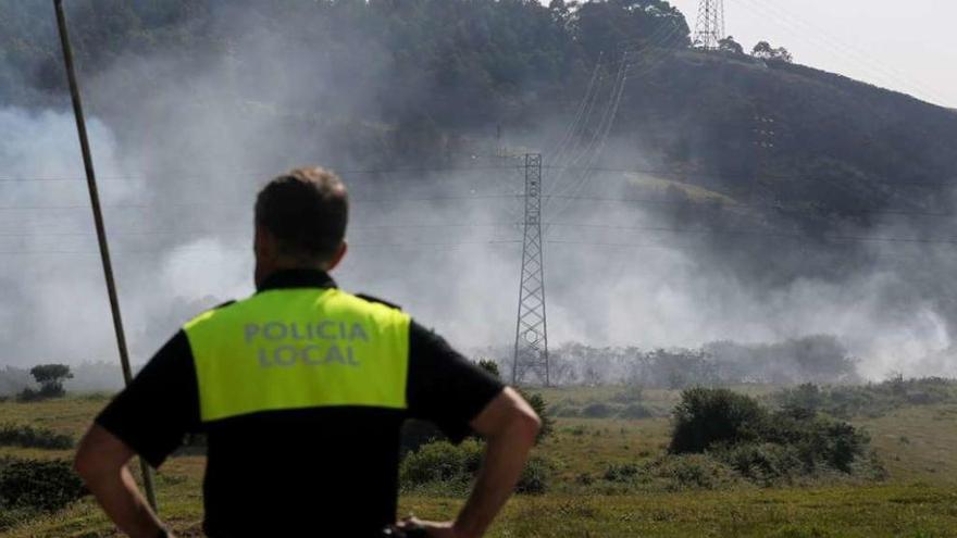 Un policía local de Gozón, durante las labores de extinción de un incendio.