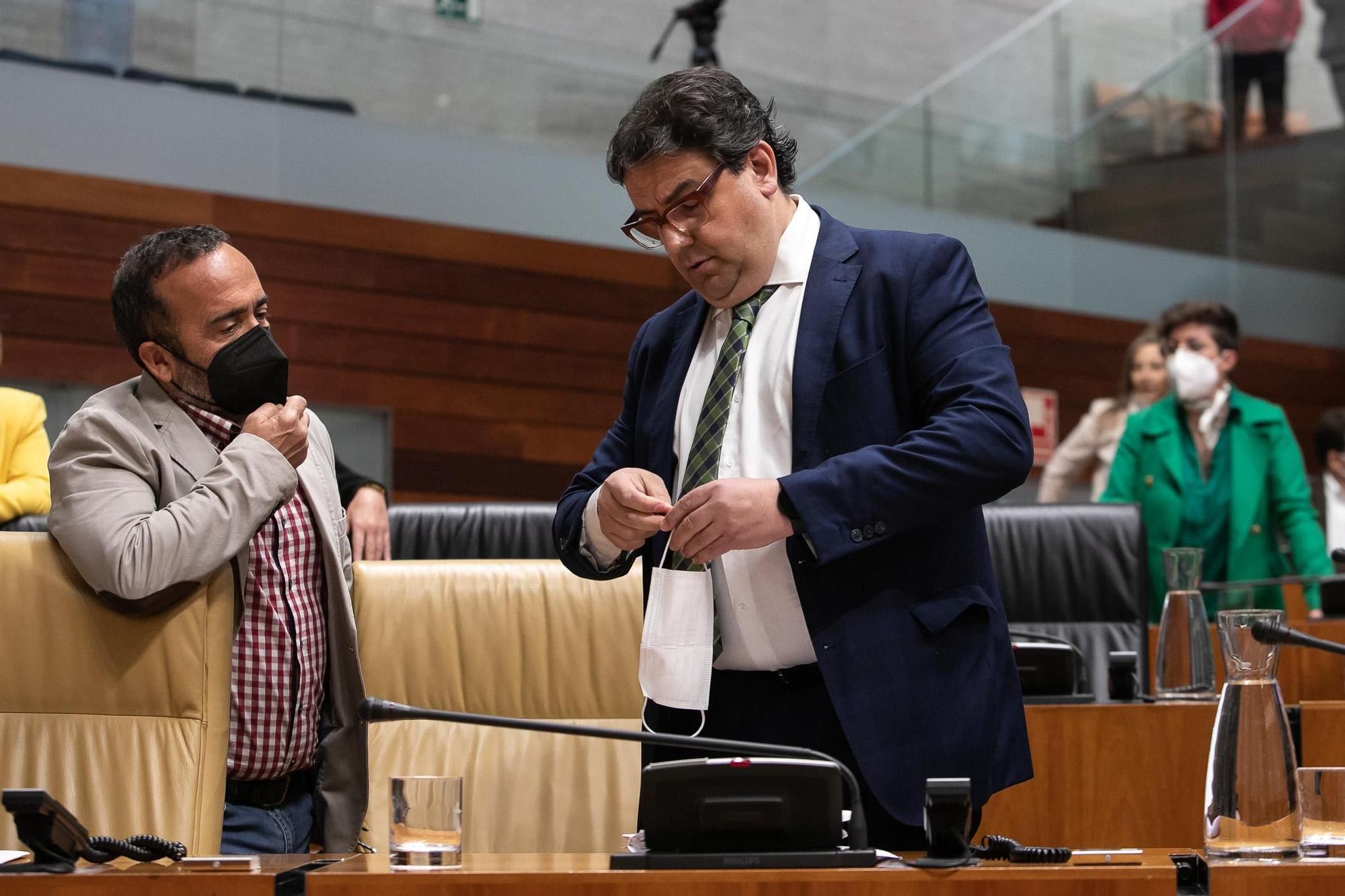 José María Vergeles se dispone a ponerse la mascarilla mientras charla con Juan Antonio Morales.