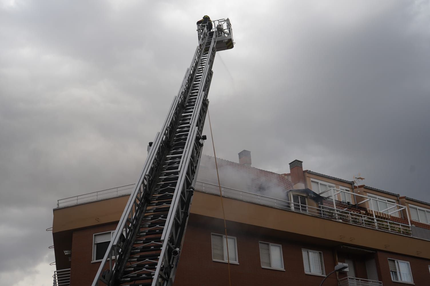 Bomberos con la escalera mecánica en la calle Almaraz