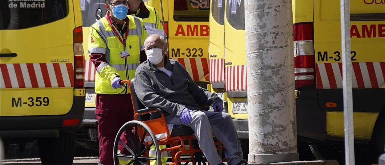 Un sanitario de ambulancia traslada a una persona mayor a la puerta del Hospital 12 de Octubre de Madrid.