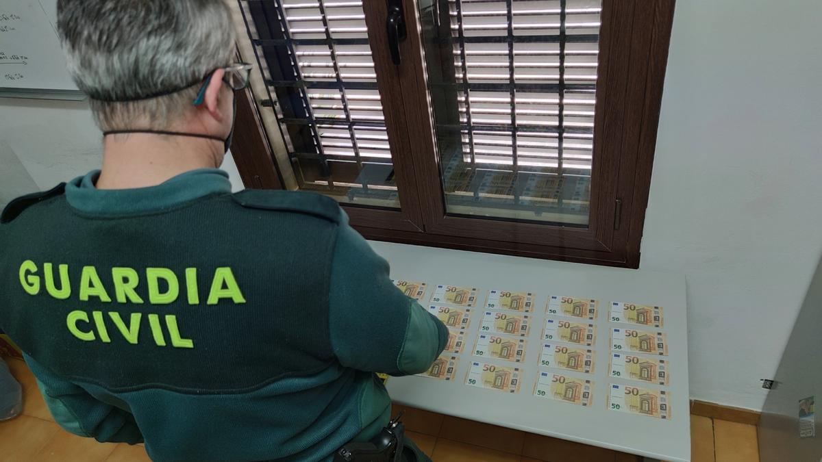 Un guardia civil examina los billetes falsos intervenidos en Cala d&#039;Or.