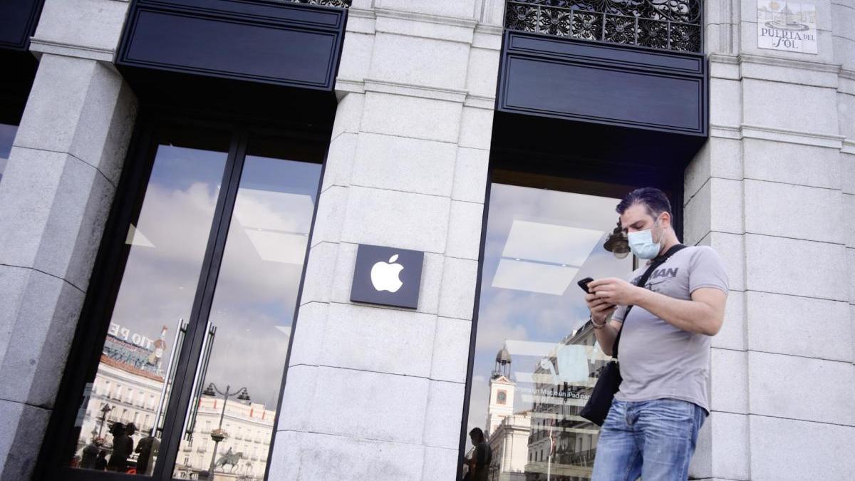 Una persona junto a la tienda Apple en la Puerta del Sol.