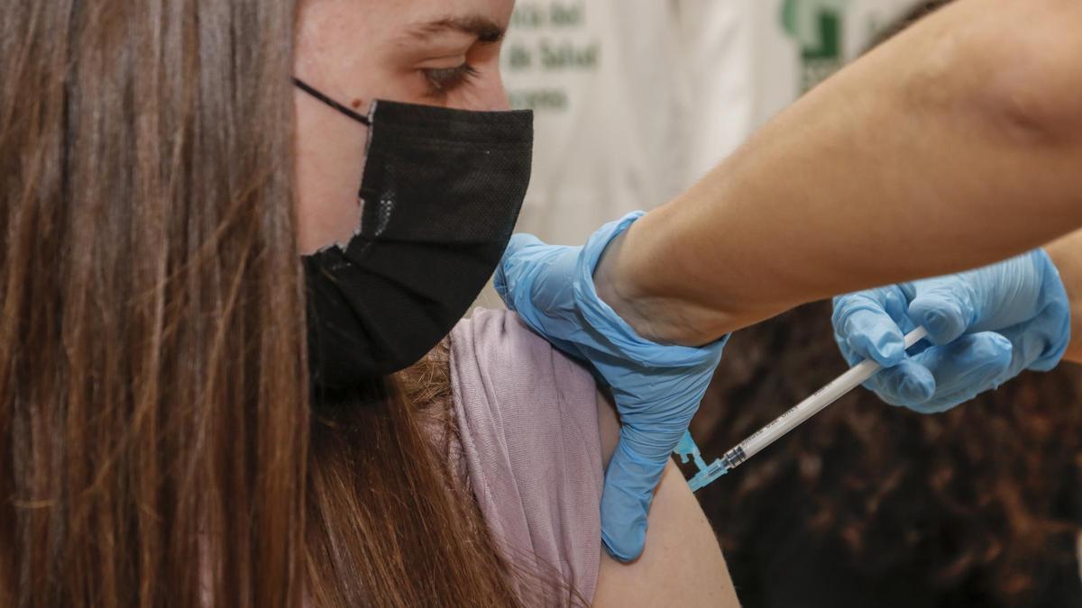 Una chica se vacuna contra el coronavirus en el Área de Salud de Cáceres.