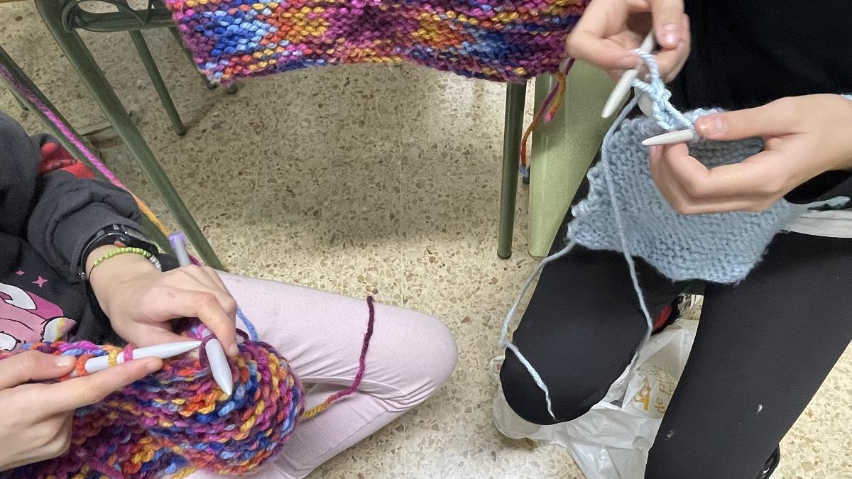 Algunos alumnos trabajan con agujas y lana para confeccionar sus propias bufandas y jerséis.