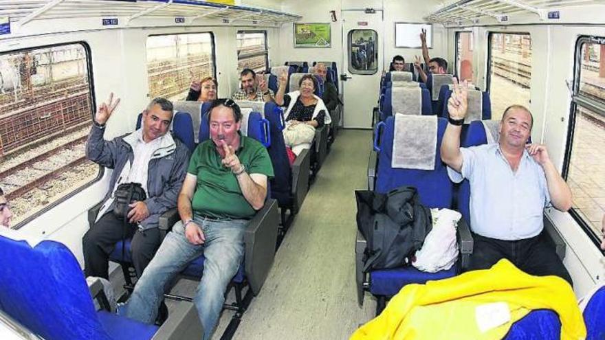 Pasajeros del tren entre Vigo y Oporto, ayer, celebrando el mantenimiento del servicio. / marta g. brea