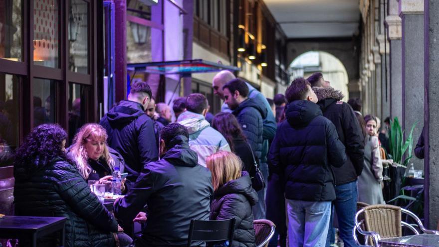 Personas en una de la terrazas resguardadas bajo los soportales de la Plaza Mayor.