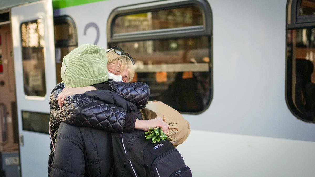 28 February 2022, Berlin: Olha Sidun hugs her sister Hanna after her arrival at Berlin Central Station. Hanna Sidun fled the war in Ukraine and took three days to get from Kiev to Berlin. Photo: Kay Nietfeld/dpa