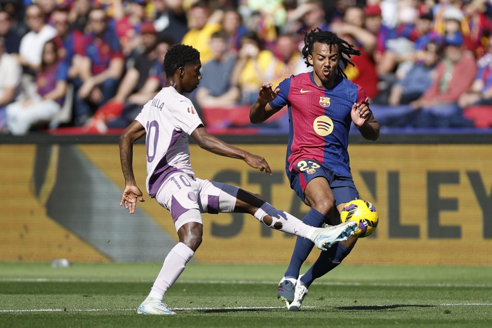 BARCELONA, 30/03/2025.- El defensa del Barcelona Jules Koundé, y el centrocampista del Girona Yaser Asprilla, durante el partido de la jornada 29 de LaLiga que FC Barcelona y Girona disputan este domingo en el estadio Lluis Companys de Barcelona. EFE/ Alberto Estévez
