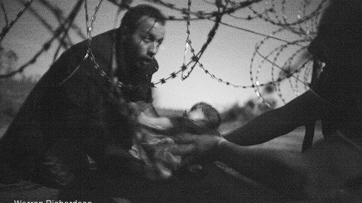 Un refugiado con su bebé en la valla de la frontera de Hungría, la foto de Warren Richardson ganadora del World Press Photo 2016.