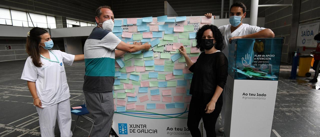 Cristina Otero y Juanjo García colocan sus mensajes en el Recinto Ferial junto a dos profesionales sanitarios.  // Gustavo Santos