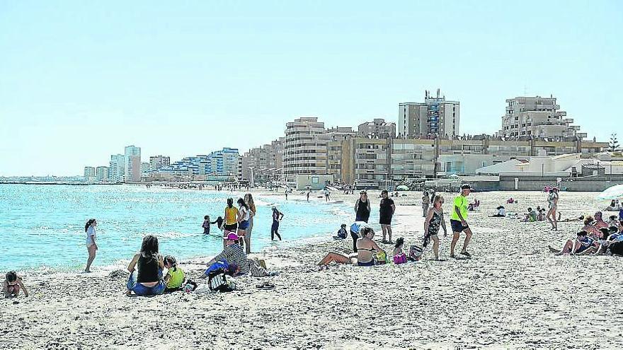 Turistas disfrutan de la arena y el mar, ayer en La Manga.