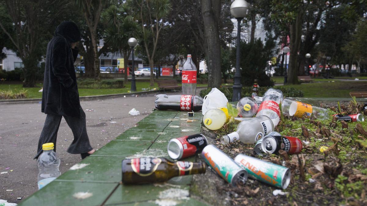 Una joven, delante de un montón de botellas en un parque, el 1 de enero de 2020.