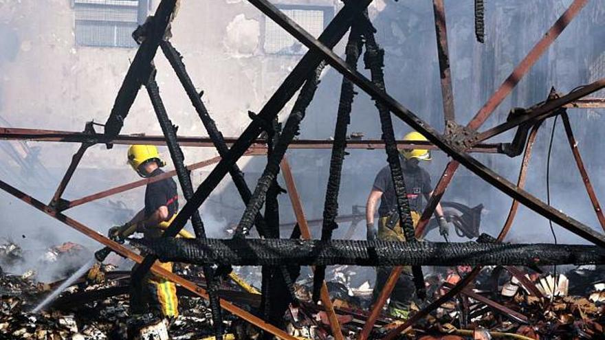 El incendio provocó el derrumbe del techo de madera en una vieja nave de la empresa Alfombras Imperial