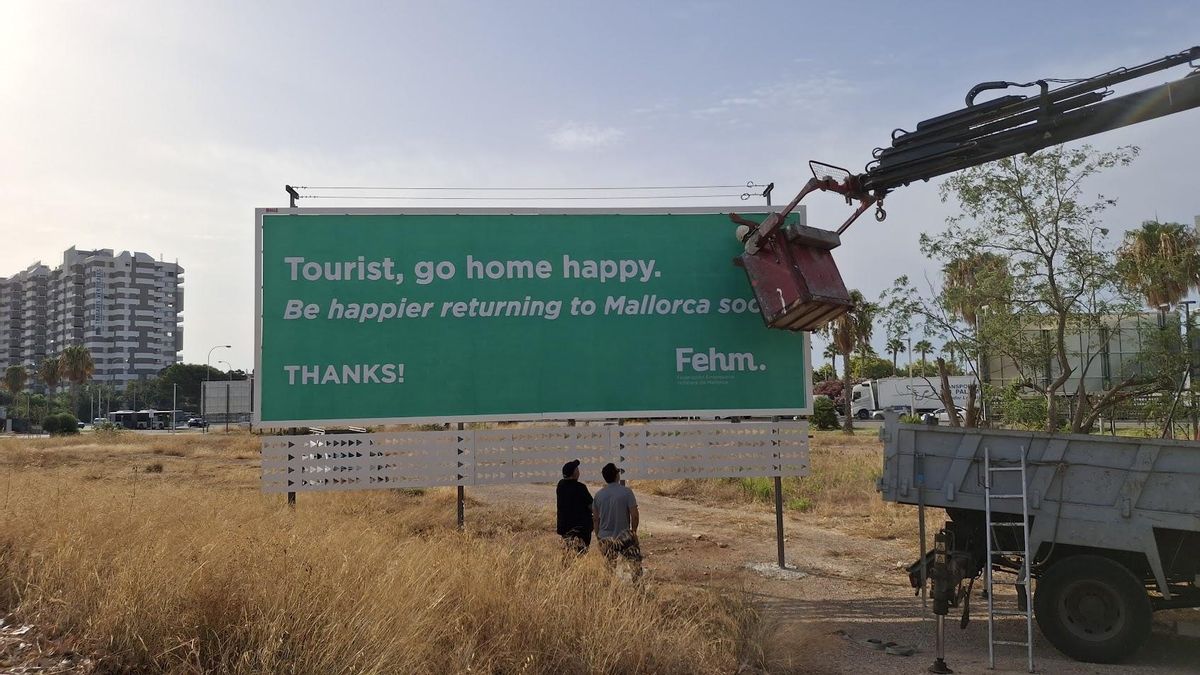 Arbeiter bringen das erste Plakat der neuen Touristen-Kampagne der Hoteliers an.