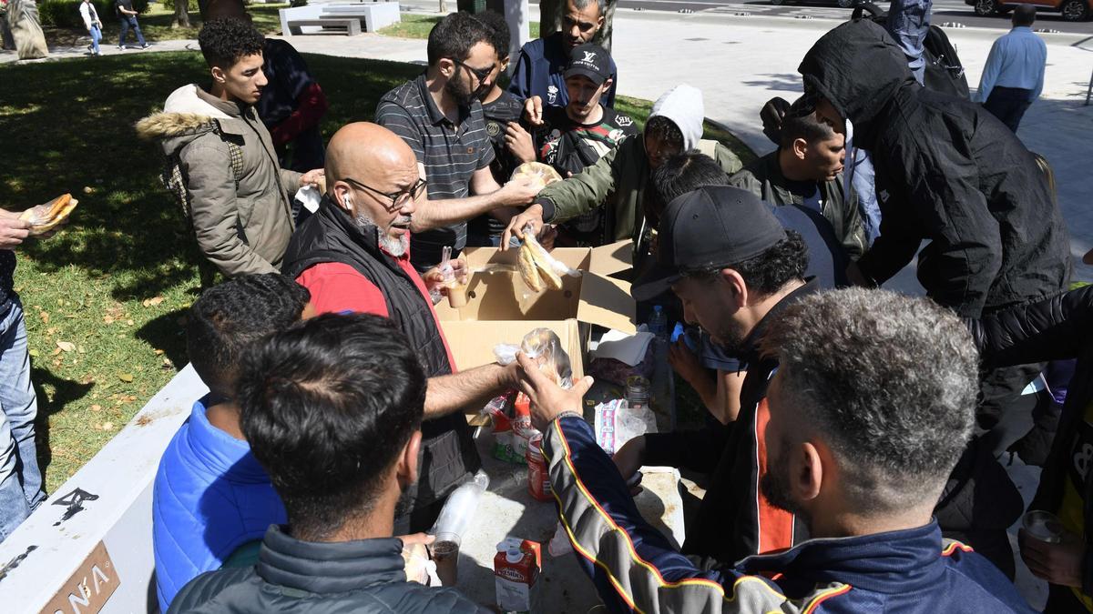 Tres voluntarios de la asociación Abeto reparten medio de centenar de desayunos a personas en situación de calle a diario en la plaza Cruz Roja.