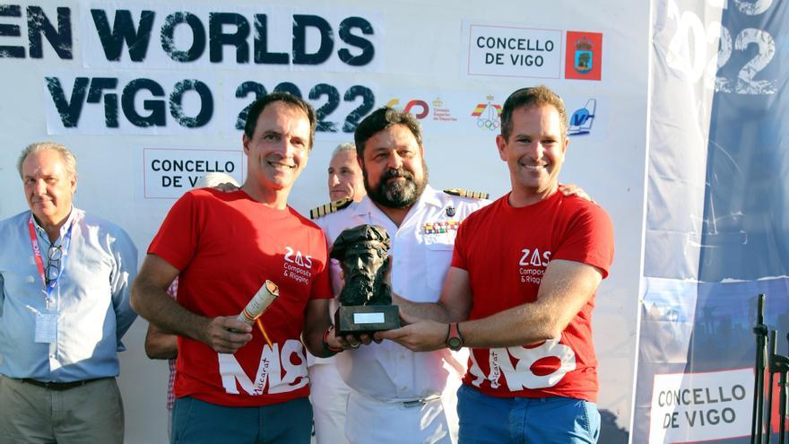 Francesco Zampacavallo (izquierda) y Carlos Francés levantan el trofeo, ante un representante de la Comandancia Naval de Vigo, durante la entrega de trofeos del Mundial de Vigo.