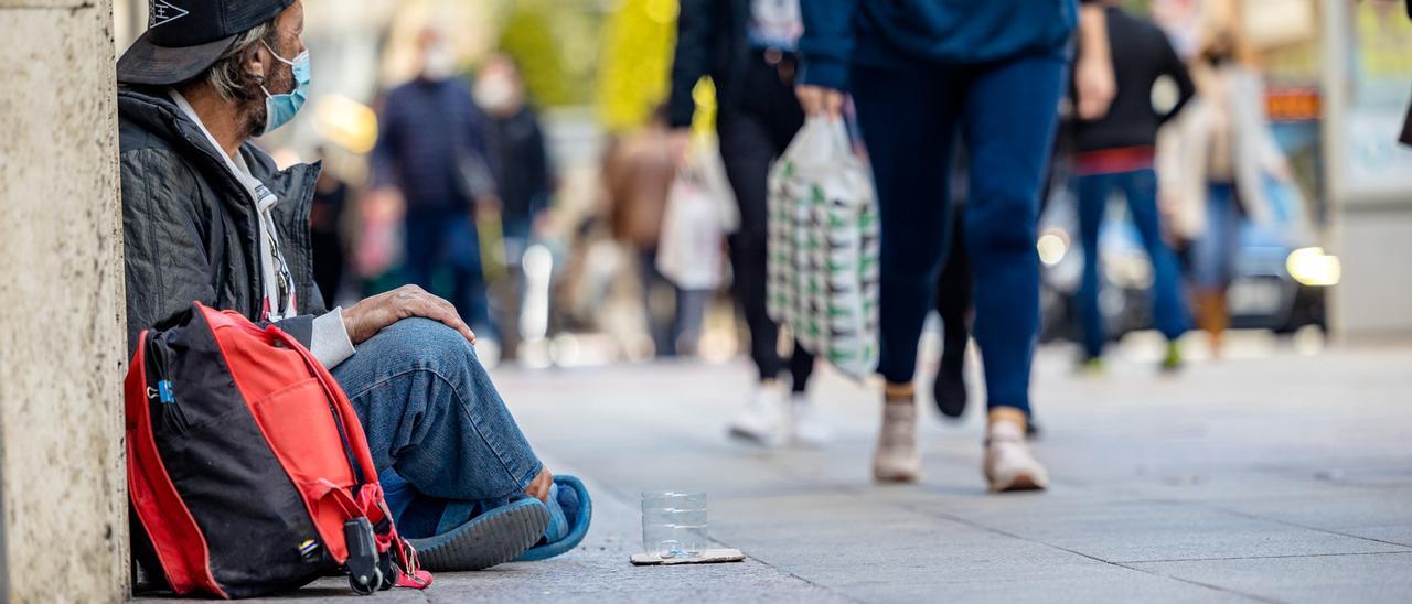 Una persona pidiendo limosna en una calle de Alicante