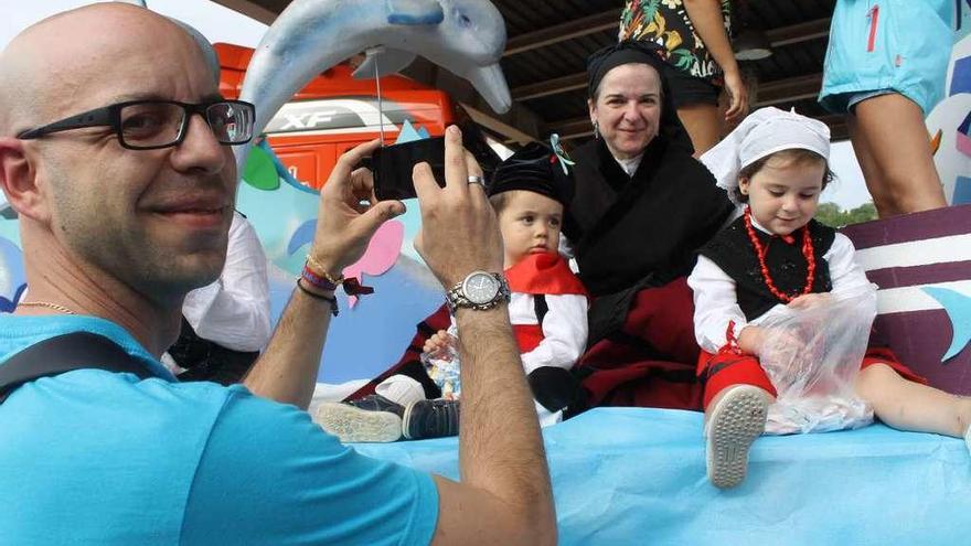 José María Castro hace una foto a su pareja, Paula Pérez, y a sus sobrinos Miguel y Valentina Zini, subidos en una de las carrozas del desfile.