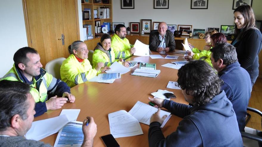 Los nuevos trabajadores firman sus contratos, ante la presencia del alcalde, Andrés Iglesias. / FdV