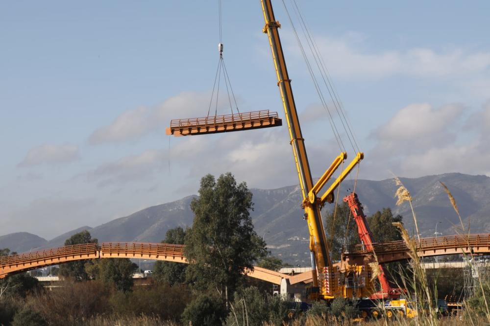 La instalación del último tramo del puente de madera sobre el río Guadalhorce ha comenzado este martes.