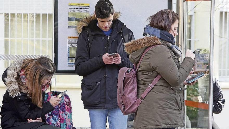 Estudiantes absortos en sus móviles en el entorno del campus histórico de Torrecedeira. // Marta G. Brea