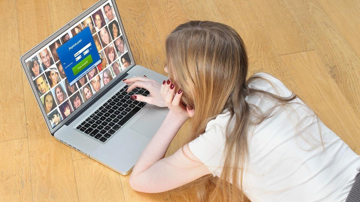 Una joven, mirando la pantalla de un ordenador.