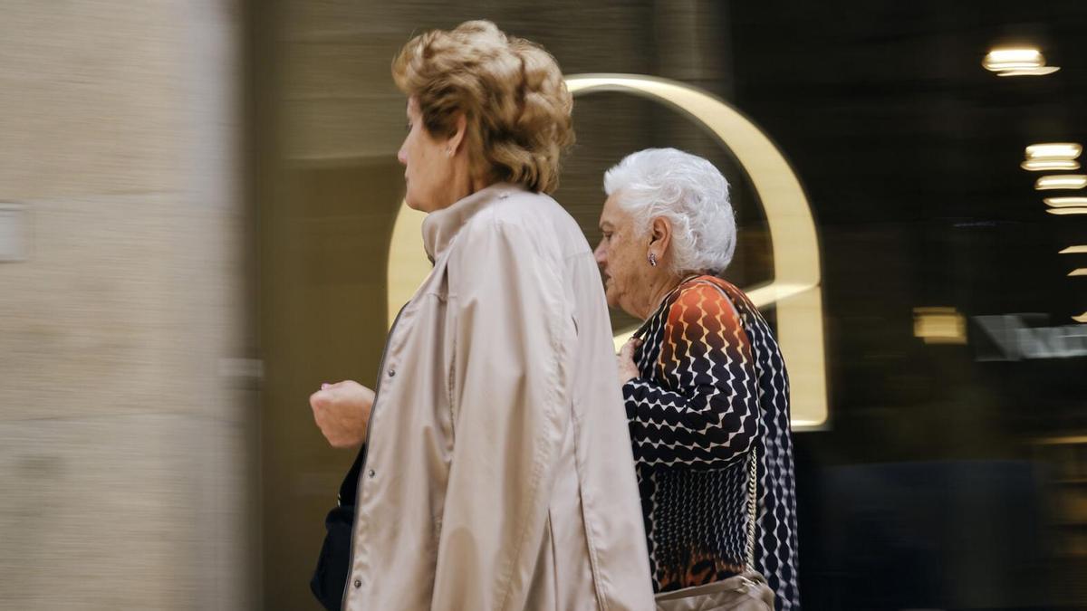 Dos mujeres mayores caminan por la ciudad.