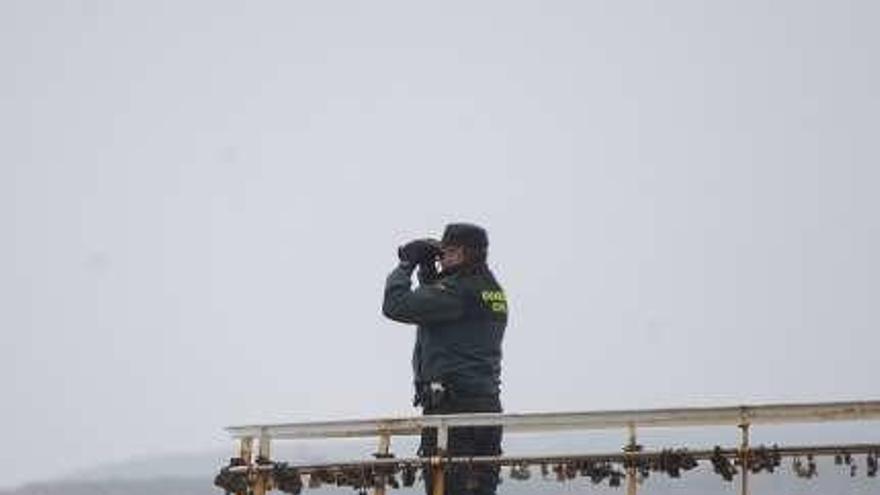 Un guardia civil observa con prismáticos, ayer, en Salinas.