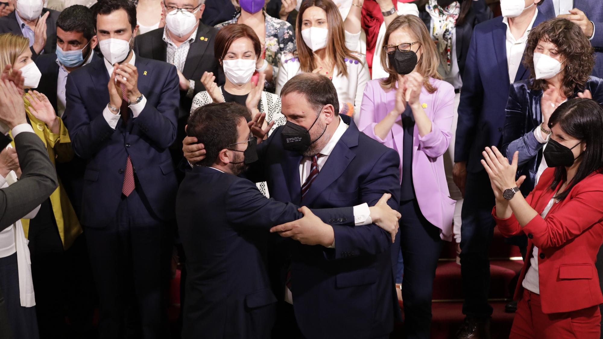 El nuevo presidente de la Generalitat, Pere Aragonès (a la izquierda), abraza al presidente de ERC, Oriol Junqueras, tras ser elegido por mayoría absoluta, este viernes.