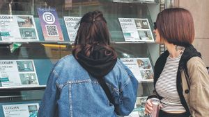 Dos chicas jóvenes buscan ofertas de alquiler en una inmobiliaria de Barcelona, en julio pasado.