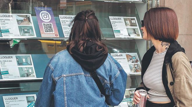 Dos chicas jóvenes buscan ofertas de alquiler en una inmobiliaria de Barcelona, en julio pasado.