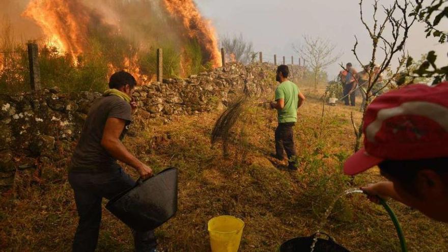 Vecinos de Pontesampaio luchando contra uno de los incendios declarados este verano. // G. Santos