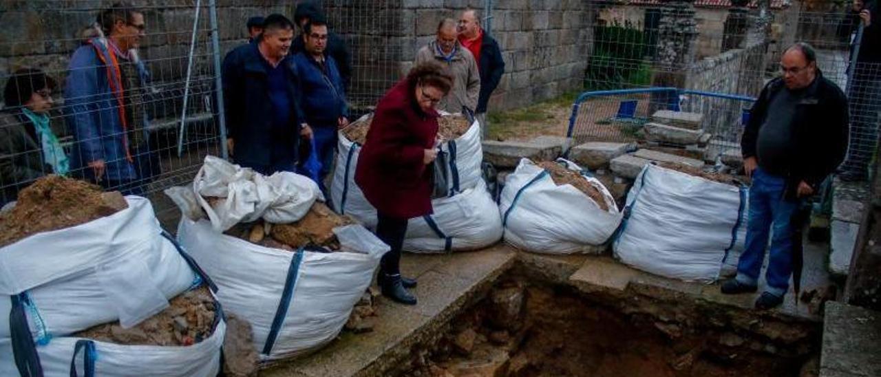 Antonio Castro, a la derecha, muestra la excavación abierta en el atrio de la iglesia de San Benito.   | // IÑAKI ABELLA